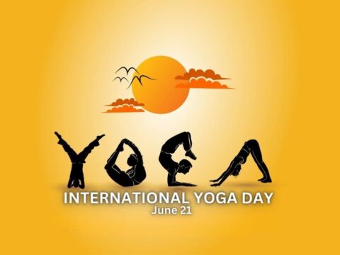 A poster featuring silhouetted figures performing various yoga poses with a warm, gradient yellow background that merges into an orange sun setting behind fluffy clouds. The text "INTERNATIONAL YOGA DAY June 21" is prominently displayed.
