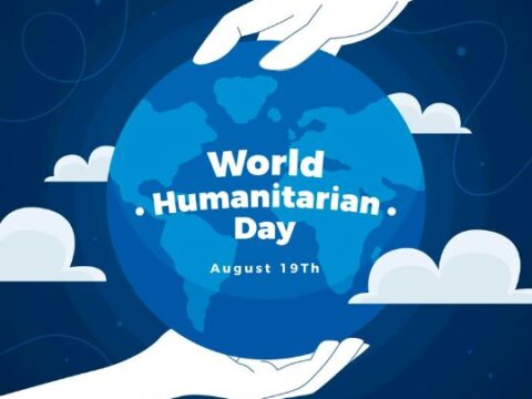 Illustration for World Humanitarian Day, showing two hands gently holding a stylized globe with a map in blue, surrounded by clouds. Text above reads 'World Humanitarian Day' and below 'August 19th' on a dark blue background.