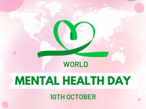 World Mental Health Day poster featuring a pink and green theme, with a stylized heart-shaped ribbon logo over a map of the world. The text reads "World Mental Health Day - 10th October."
