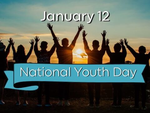 Group of silhouetted people raising their hands against a sunrise backdrop with text 'January 12' and 'National Youth Day' on a blue ribbon banner