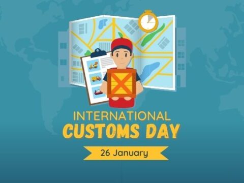 The image is a promotional graphic for International Customs Day, observed on January 26. It features a cartoon character, presumably a customs officer, holding a clipboard with various icons related to travel and trade. The character stands in front of a stylized world map and a large clock, symbolizing global trade and timely operations. The design incorporates a modern and approachable style to raise awareness about the role of customs in international trade and regulation.