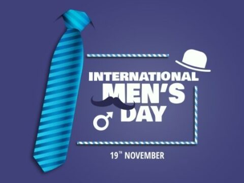 Promotional image for International Men's Day featuring a blue striped tie and a graphic mustache with the text 'International Men's Day and the date '19th November' on a purple background, from the blog ashadiaries.in.